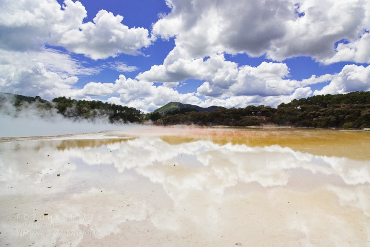 aufsteigender Dampf über gelber Fläche mit Wolkenspiegelung