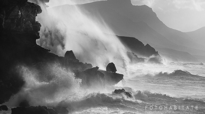 Brandung an Felsen in schwarzweiß
