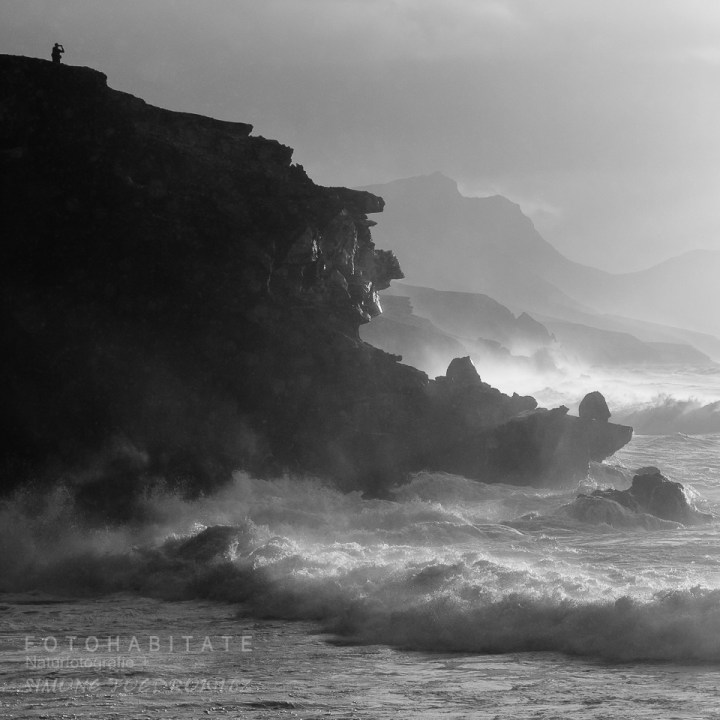 Mann auf Felsklippe bei stürmischer See
