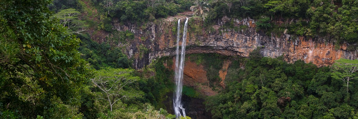 Wasserfall über gebogenen Felsen im Dschungel