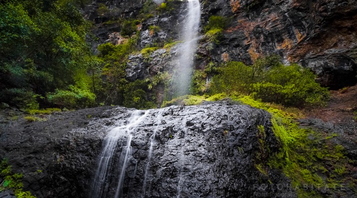 Von Felden über Steine herabfallender Wasserfall im Regenwald