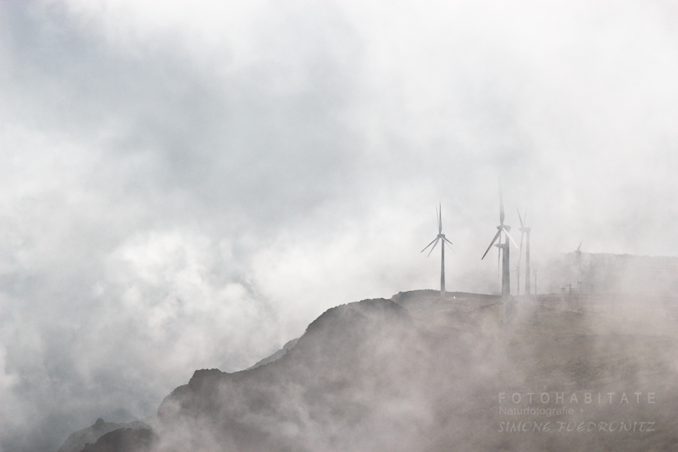 Wolken über Bergen mit Windrädern
