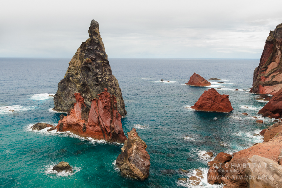 orange spitze Felsen in blauem Meer