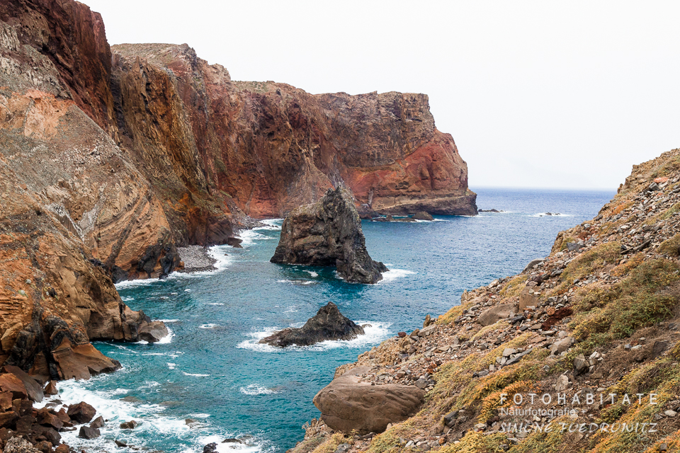 orangegelbe Felsbucht mit blauem Meer