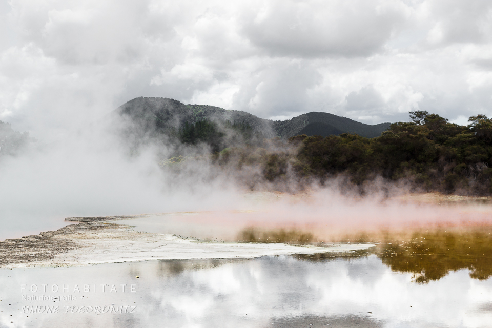 Wasserdampf steigt aus See auf vor Bergen