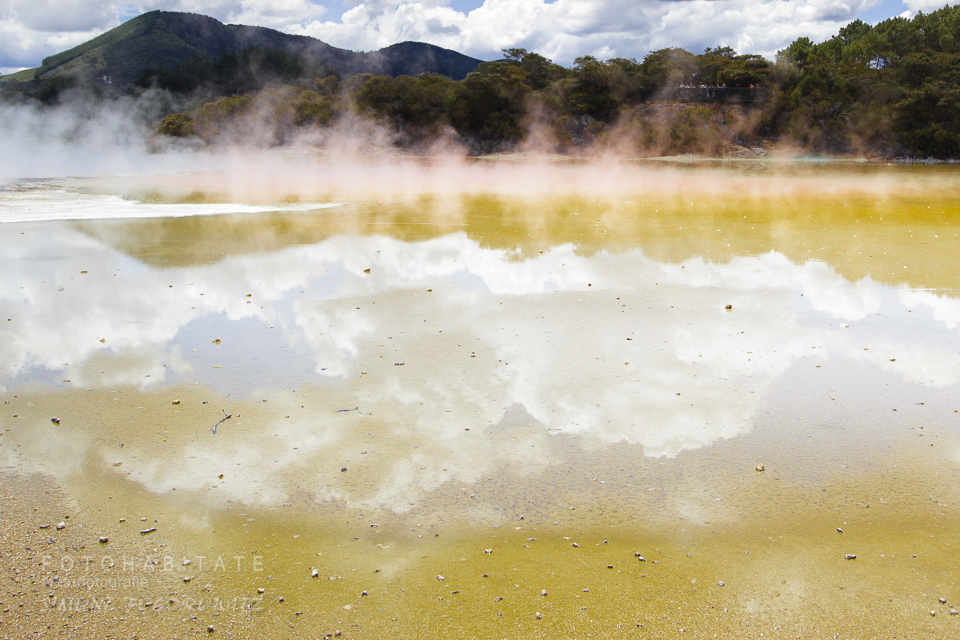 Wolken spiegeln sich in See, aus dem Wasserdampf aufsteigt
