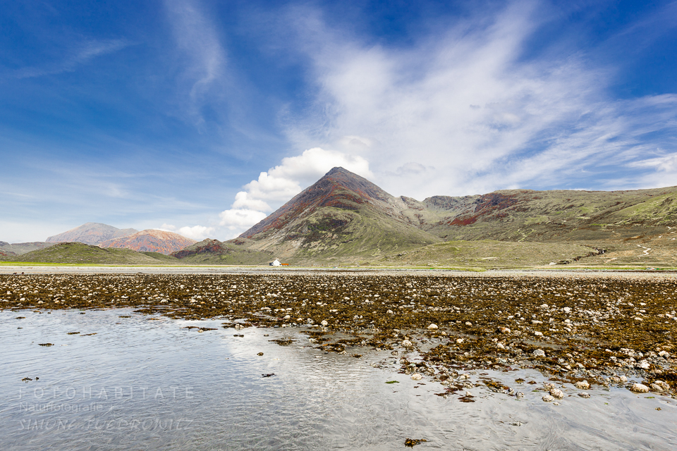 Ebbe am Strand mit Bergen