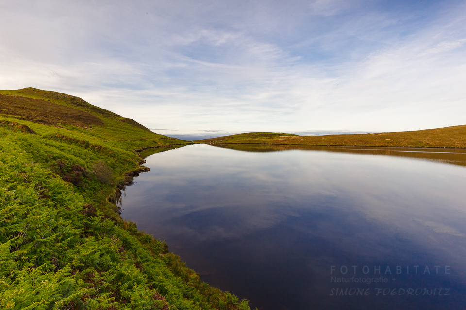 See spiegelt blauen Himmel
