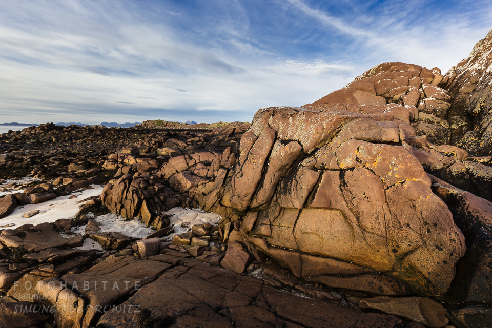 rote Felsen unter blauen Himmel am Strand