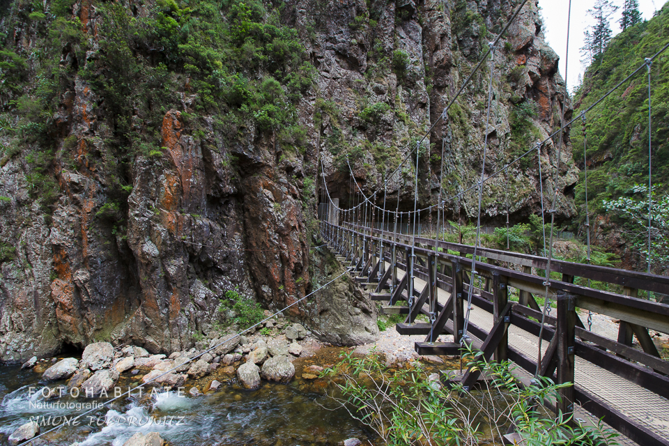 Hängebrücke über Fluss in Schlucht