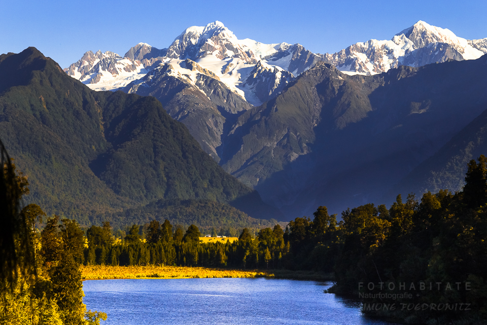 blauer See vor schneebedeckten Gipfeln