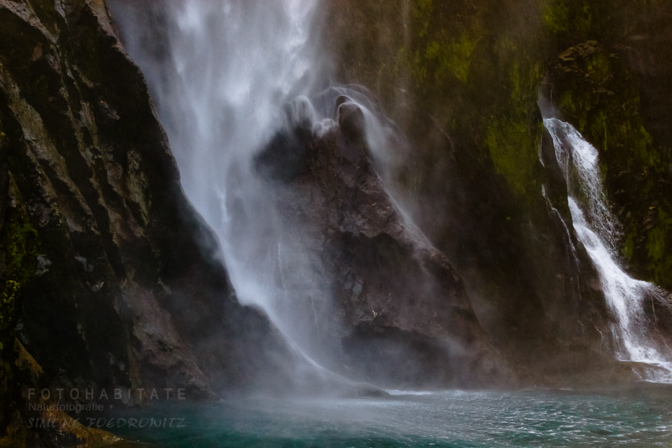 Wasserfall auf grün bemoosten schwarzen Felsen
