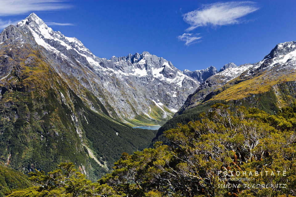 See zwischen regenwaldbewachsenen Bergen und schneebedeckten Gipfeln