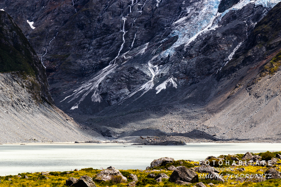 Wasser vor teils mit eisbedeckten Berghängen
