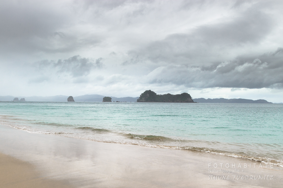 grauer wolkenverhangender Himmel über türkisem Meer